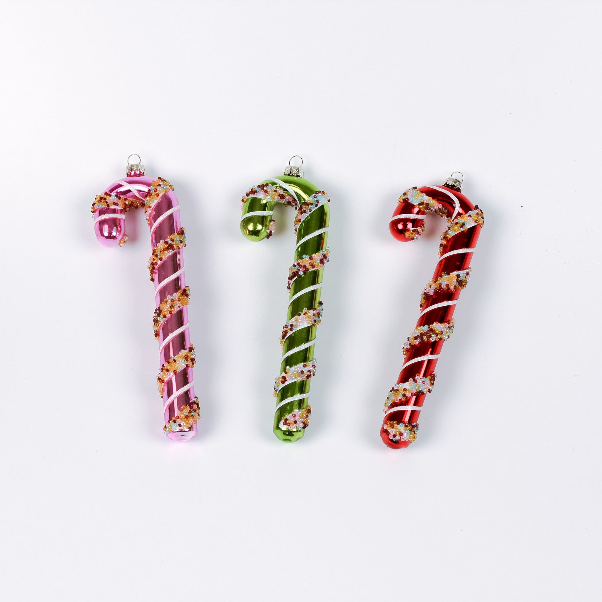 three glass candy cane ornaments on a white background