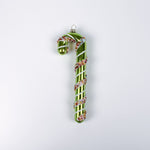 green glass candy cane ornaments on a white background