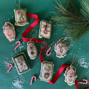 An embroidered christmas ornament set featuring all of santa's reindeer. 