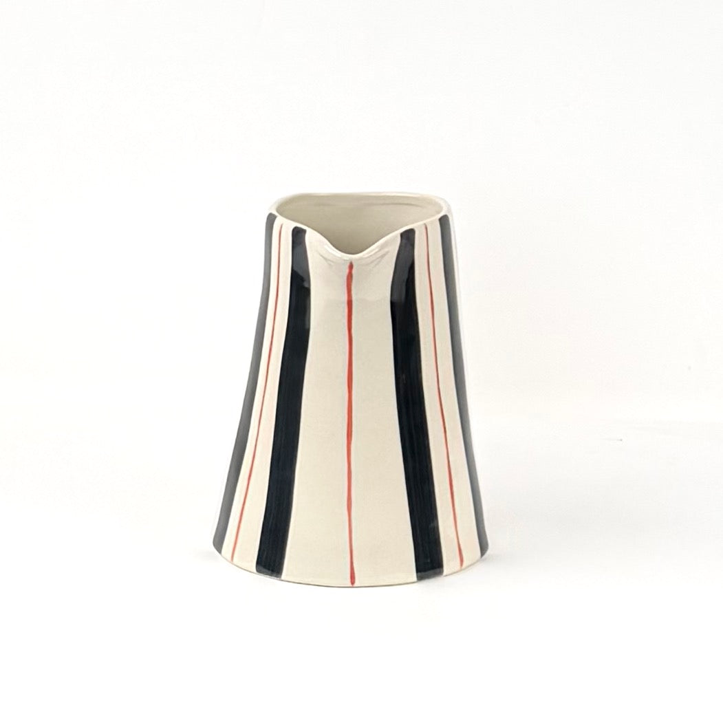 Blue and red striped pitcher front view with cream ceramic finish and hand painted vertical stripe pattern.