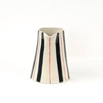 Blue and red striped pitcher front view with cream ceramic finish and hand painted vertical stripe pattern.
