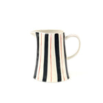 Blue and red striped pitcher with cream ceramic finish, curved handle, and hand painted vertical stripe design.