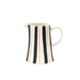 Blue and red striped pitcher with cream ceramic finish, curved handle, and hand painted vertical stripe design.