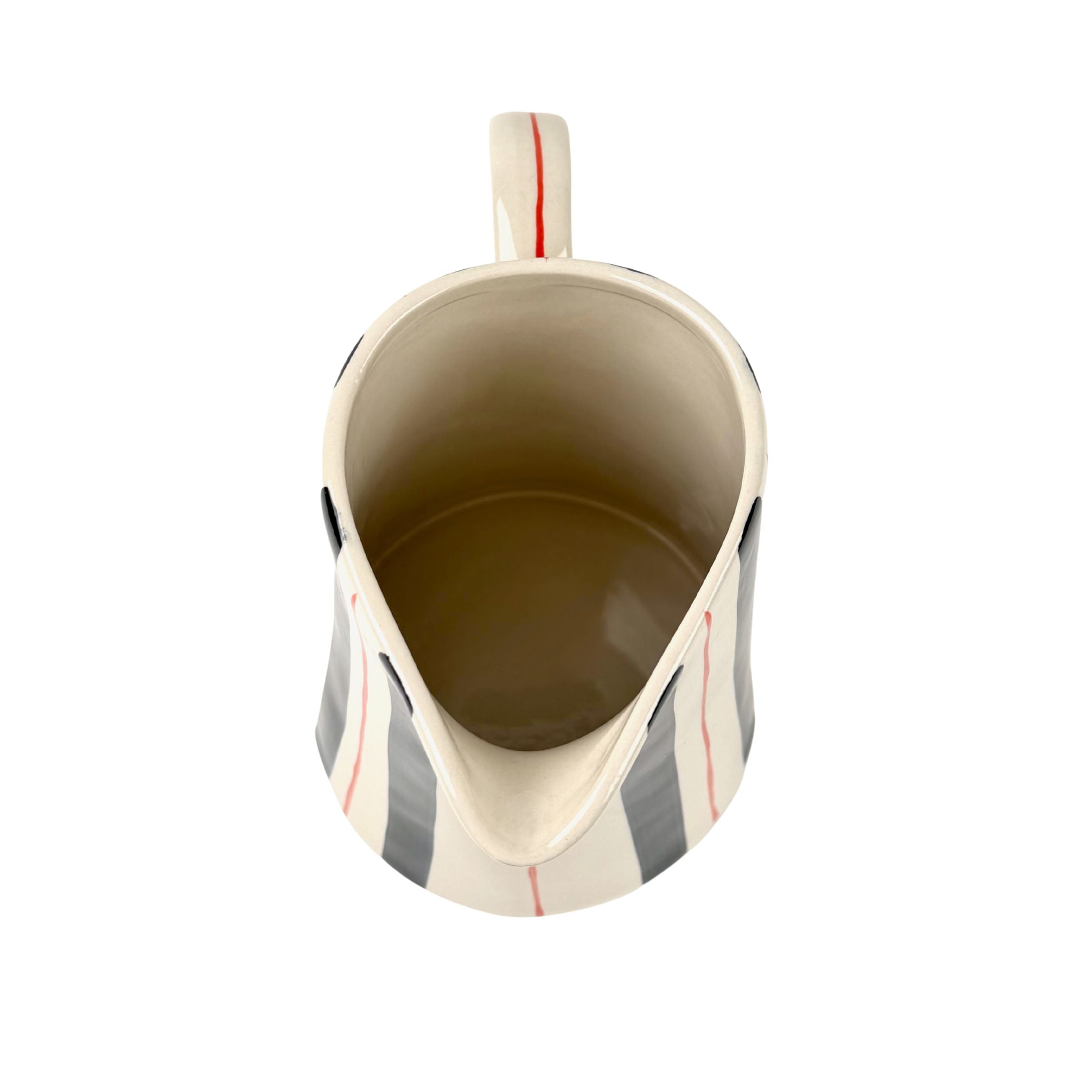 Blue and red striped pitcher top view with cream ceramic interior and curved spout opening.