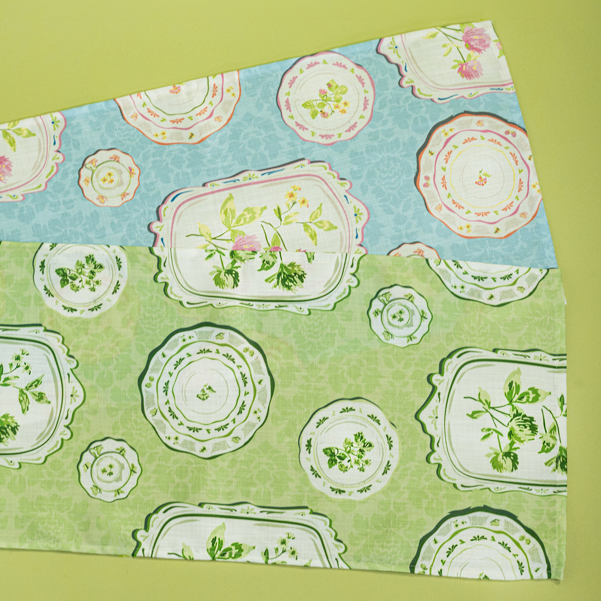 two plates fabric table runners from madcap cottage, one in blue and one in green. 