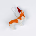 Small corgi christmas ornament with a red hat on a white background