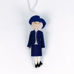 Decorative  British Royal Family ornament of Queen Camilla in a blue outfit with a hat on a white background