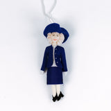 Decorative  British Royal Family ornament of Queen Camilla in a blue outfit with a hat on a white background