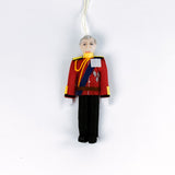 Decorative British Royal Family ornament of a person in a red uniform with a white background