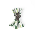 Brown and green shell napkin ring displayed on a green patterned cloth napkin.