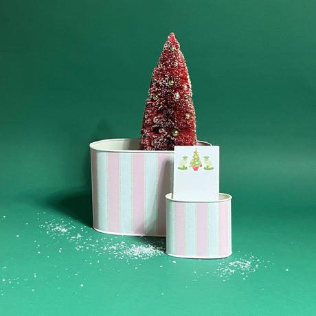duo of Cabana Boy caddies in large and small on a green bakground with a notepad and faux tree in them