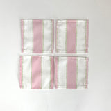 A set of four Cabana Boy white and pink stripe cloth cocktail napkins in a linen-like poly