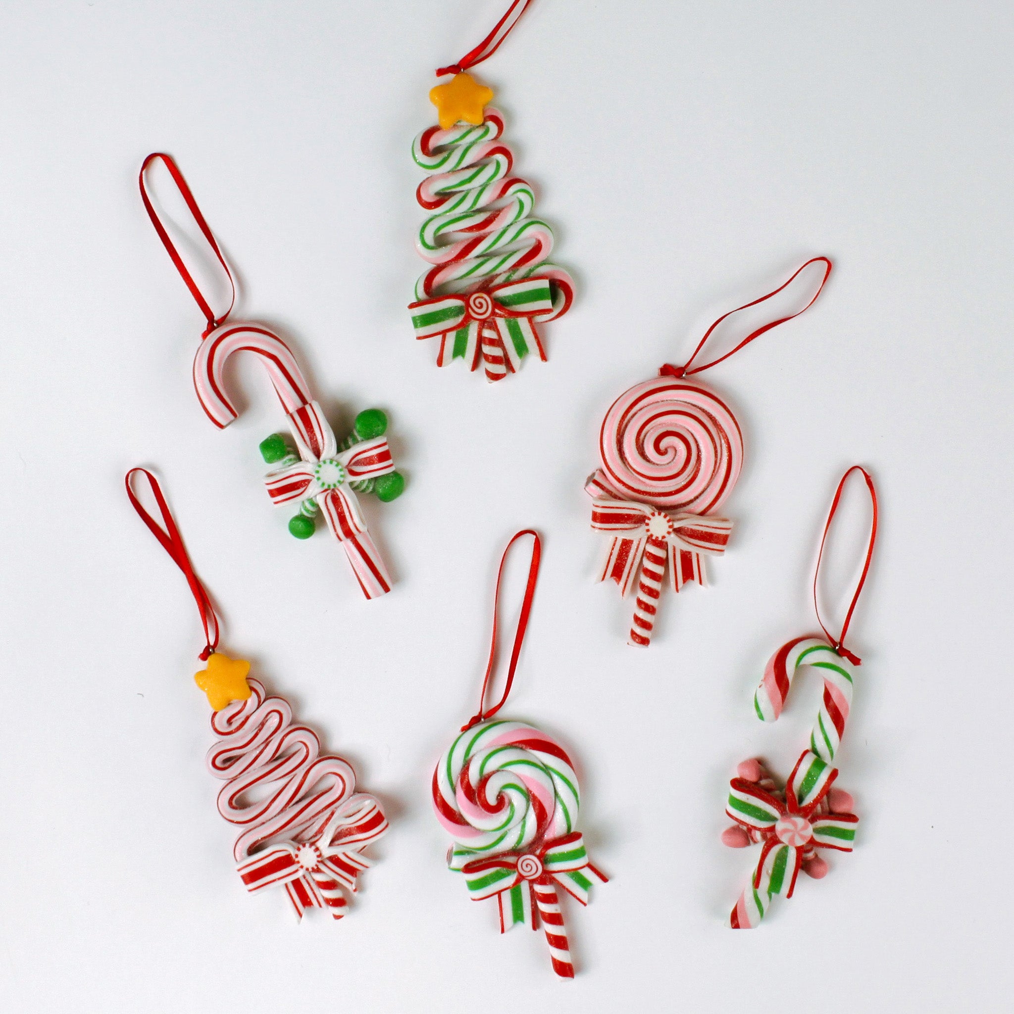 Set of six colorful candy-themed Christmas ornaments shaped like candy canes, lollipops, and Christmas trees