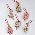 Set of six colorful candy-themed Christmas ornaments shaped like candy canes, lollipops, and Christmas trees