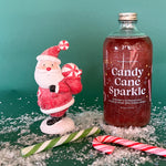16 ounce glass bottle with red candy cane flavored christmas cocktail and drink mixer with silver edible glitter