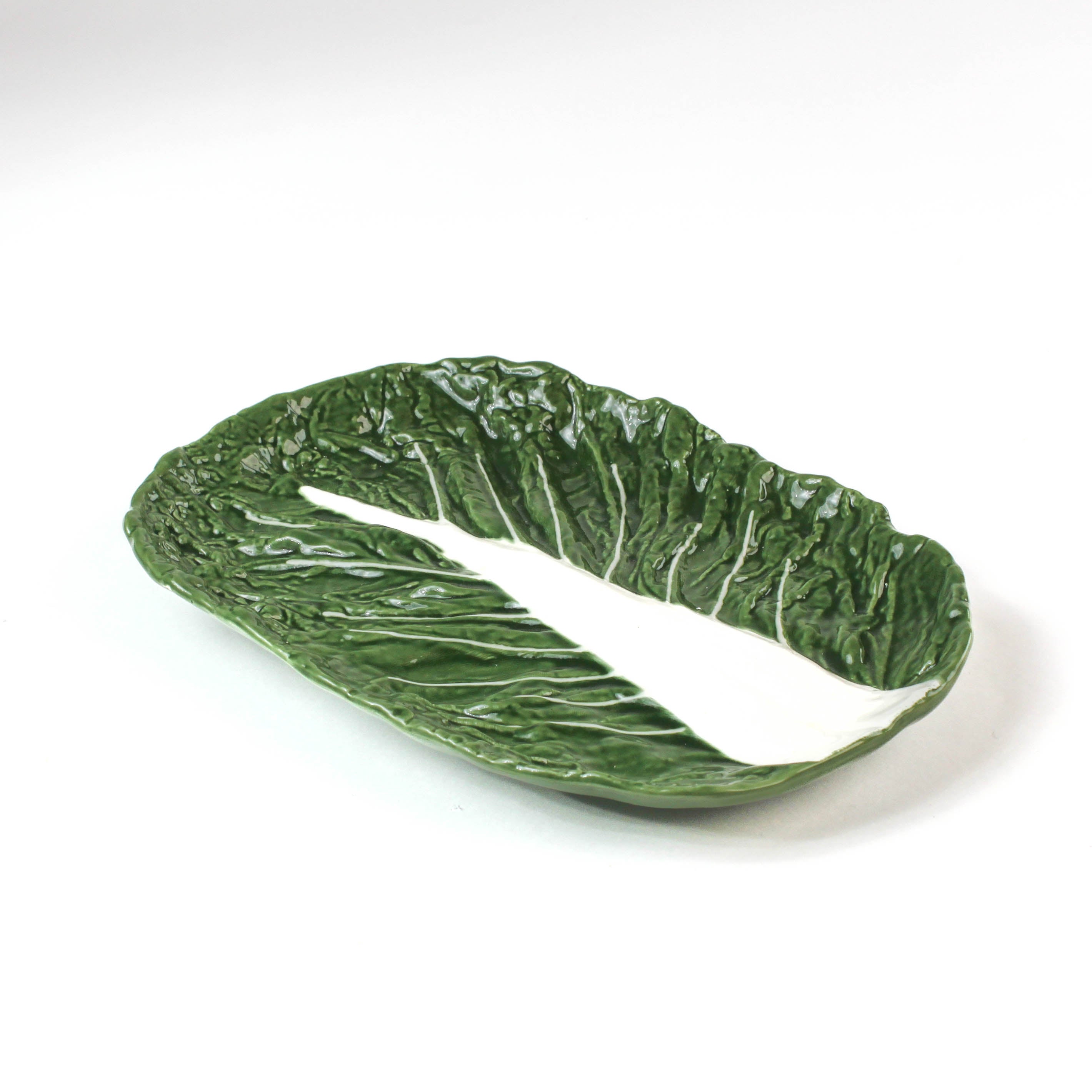 a large ceramic cabbage serving platter with white background