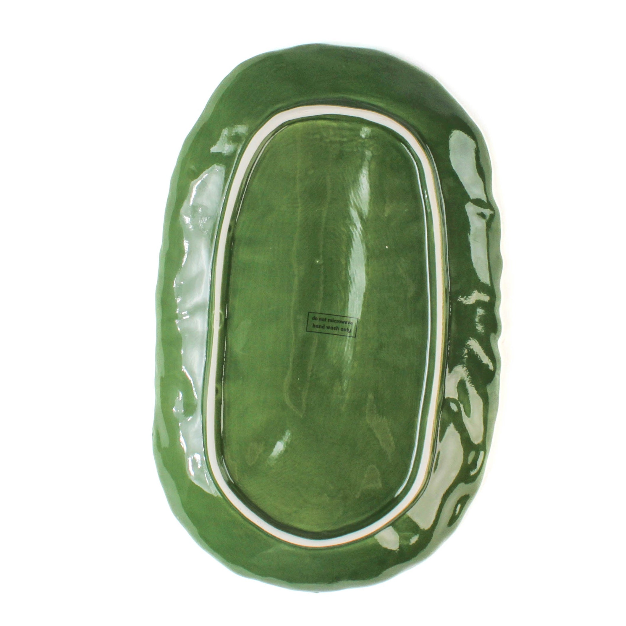 back of a large ceramic cabbage serving platter with white background