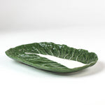 a large ceramic cabbage serving platter with white background