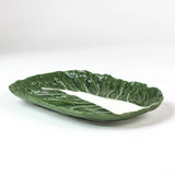 a large ceramic cabbage serving platter with white background