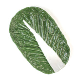 top view of a a large ceramic cabbage serving platter with white background