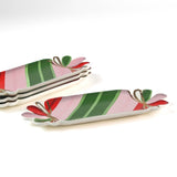four striped ceramic accent plates with candy motifs on a white surface