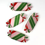 four striped ceramic accent plates with candy motifs on a white surface