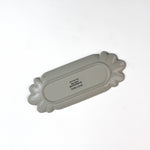 back view of a striped ceramic accent plates with candy motifs on a white surface