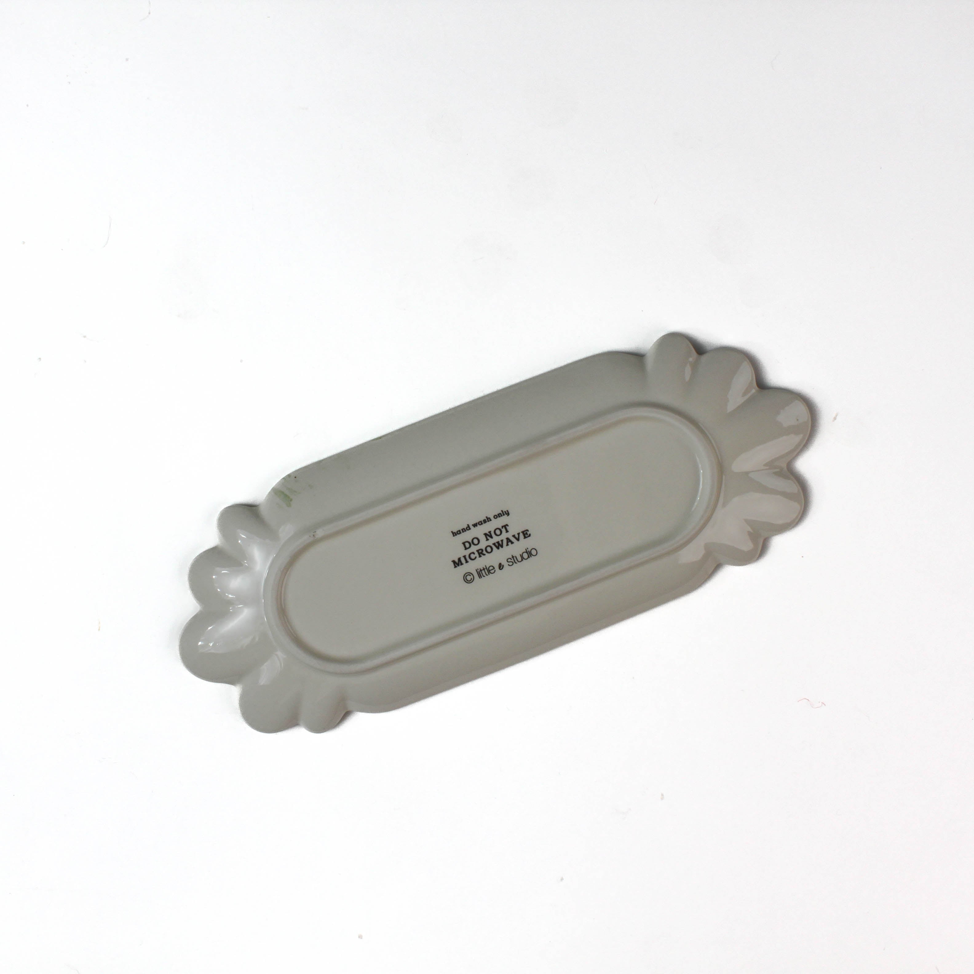 back view of a striped ceramic accent plates with candy motifs on a white surface