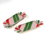 four striped ceramic accent plates with candy motifs on a white surface