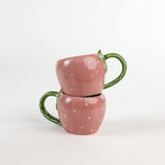 2 pink Ceramic Strawberry Mugs with green handler in a white background