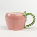 pink Ceramic Strawberry Mug with green handler in a white background
