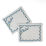 white scalloped cocktail napkins with “Cheers!” and star embroidery