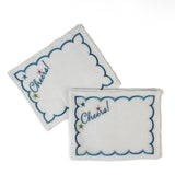 white scalloped cocktail napkins with “Cheers!” and star embroidery