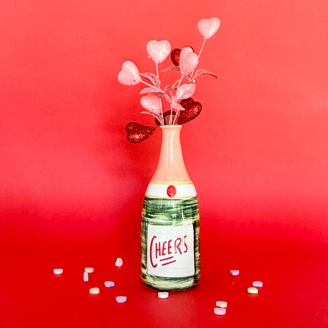 Ceramic vase with cheers written on the front.