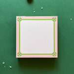 square notepad with green decorative borders, displayed on a green background