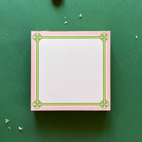 square notepad with green decorative borders, displayed on a green background