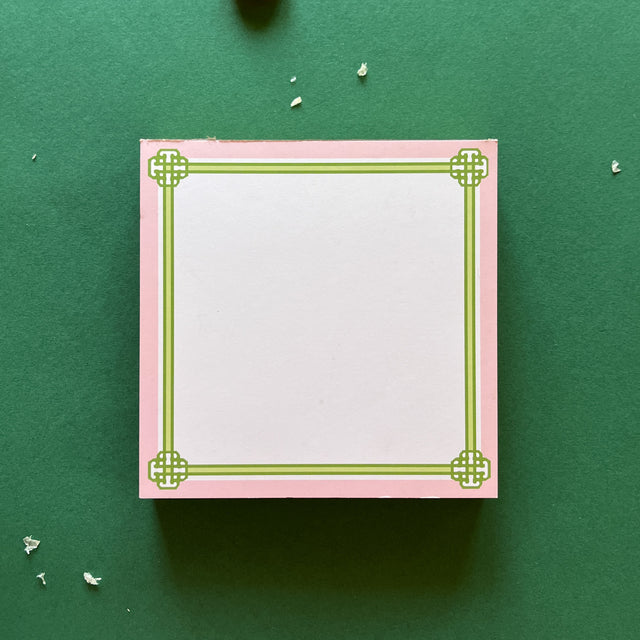 square notepad with green decorative borders, displayed on a green background