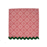 red lattice-pattern dinner napkin with green scalloped trim