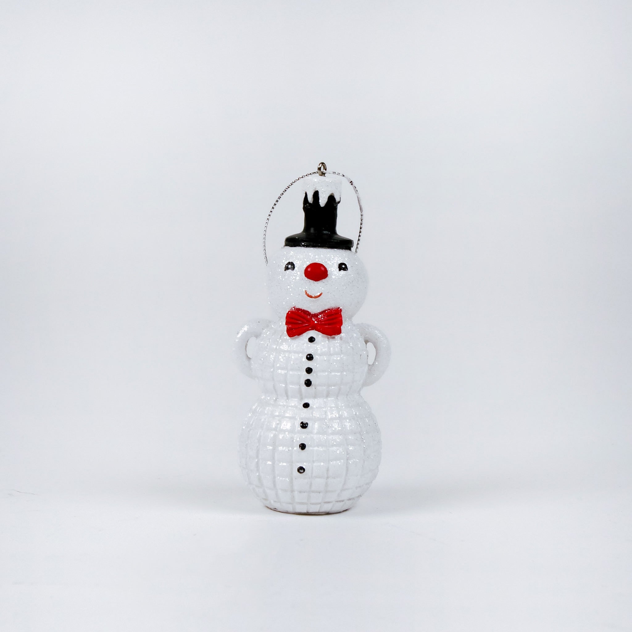 snowman ornament with a top hat, red bow tie, and black buttons on a white background