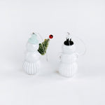 Two white glass snowman ornaments on a white background