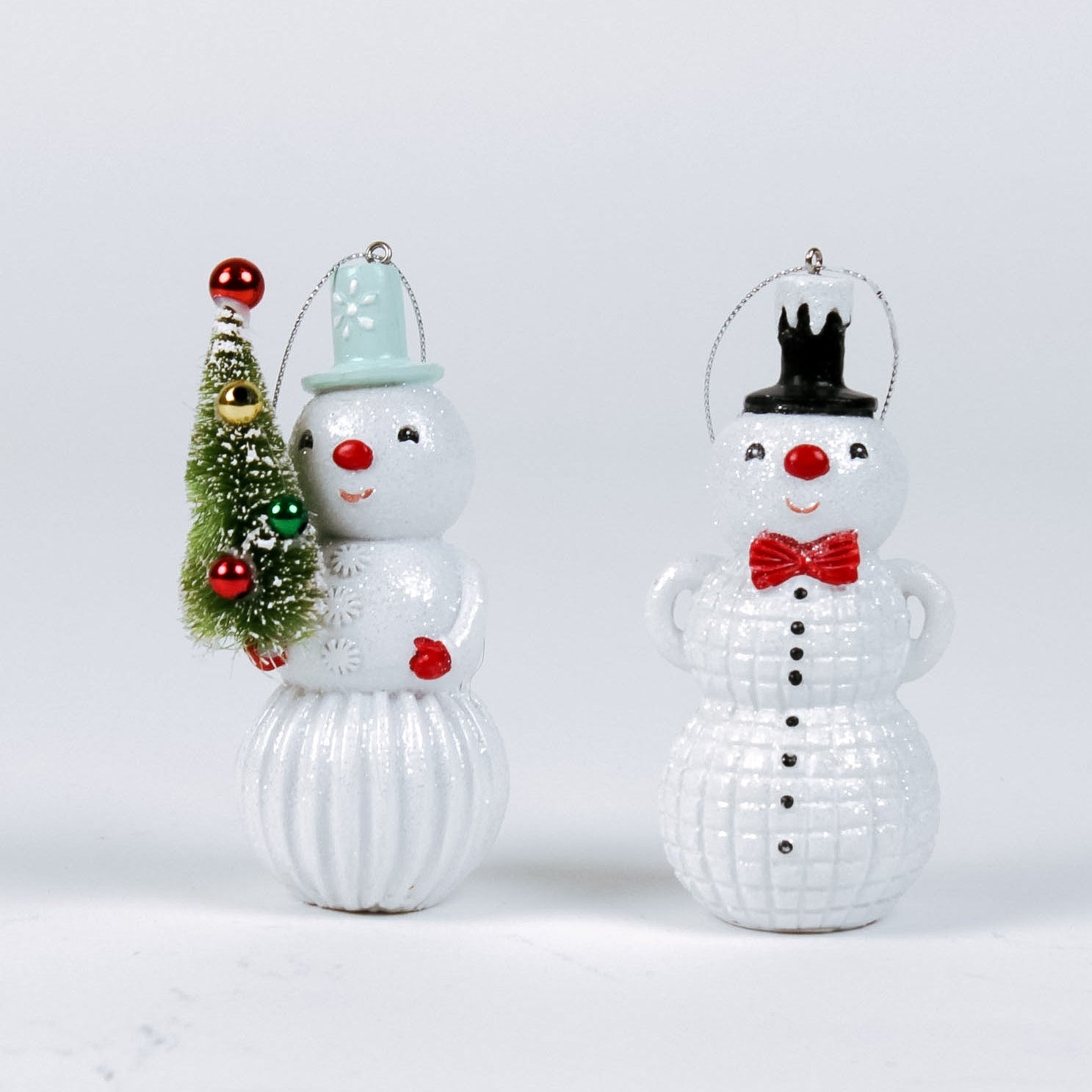 Two decorative snowman ornaments on a light gray background