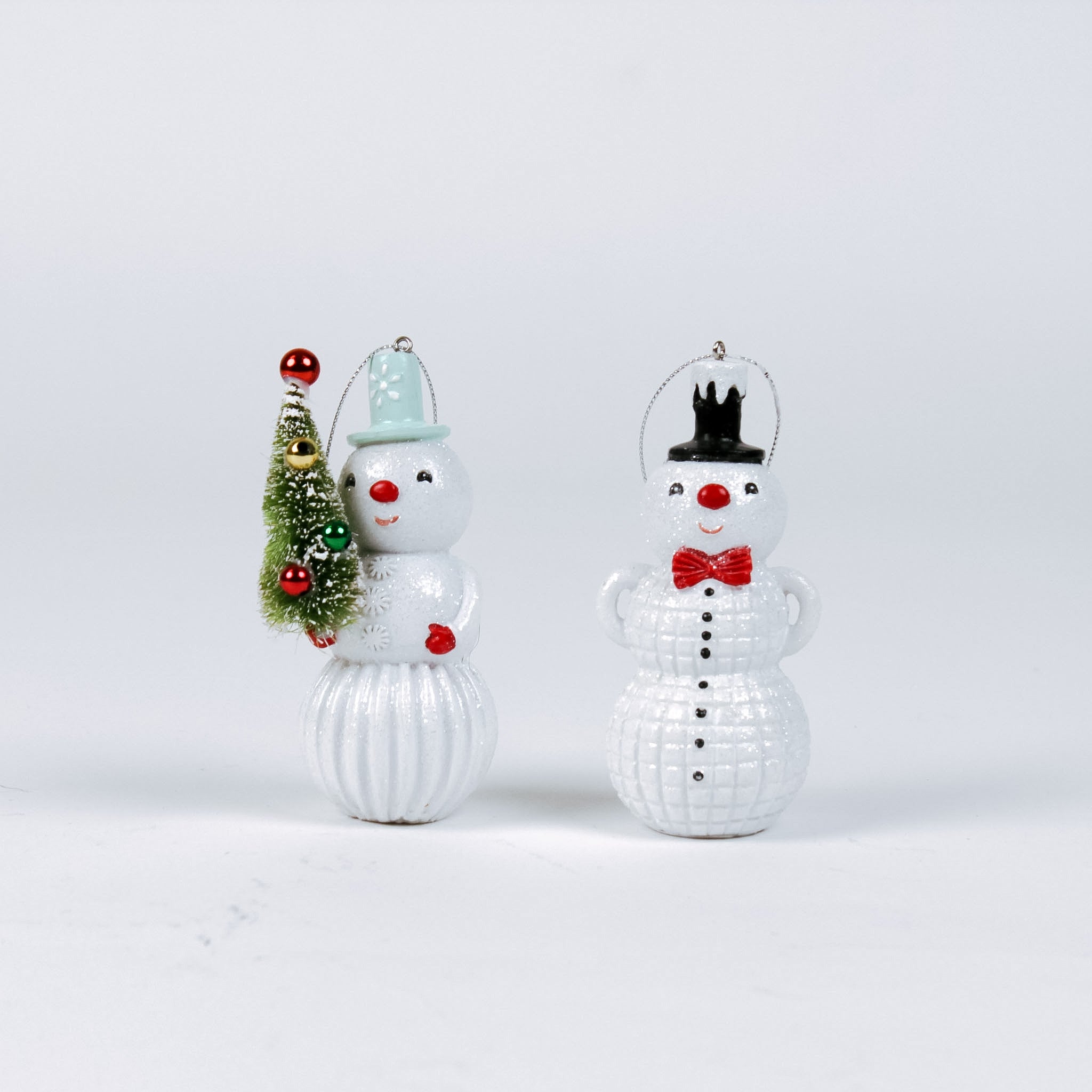 Two decorative snowman ornaments on a light gray background
