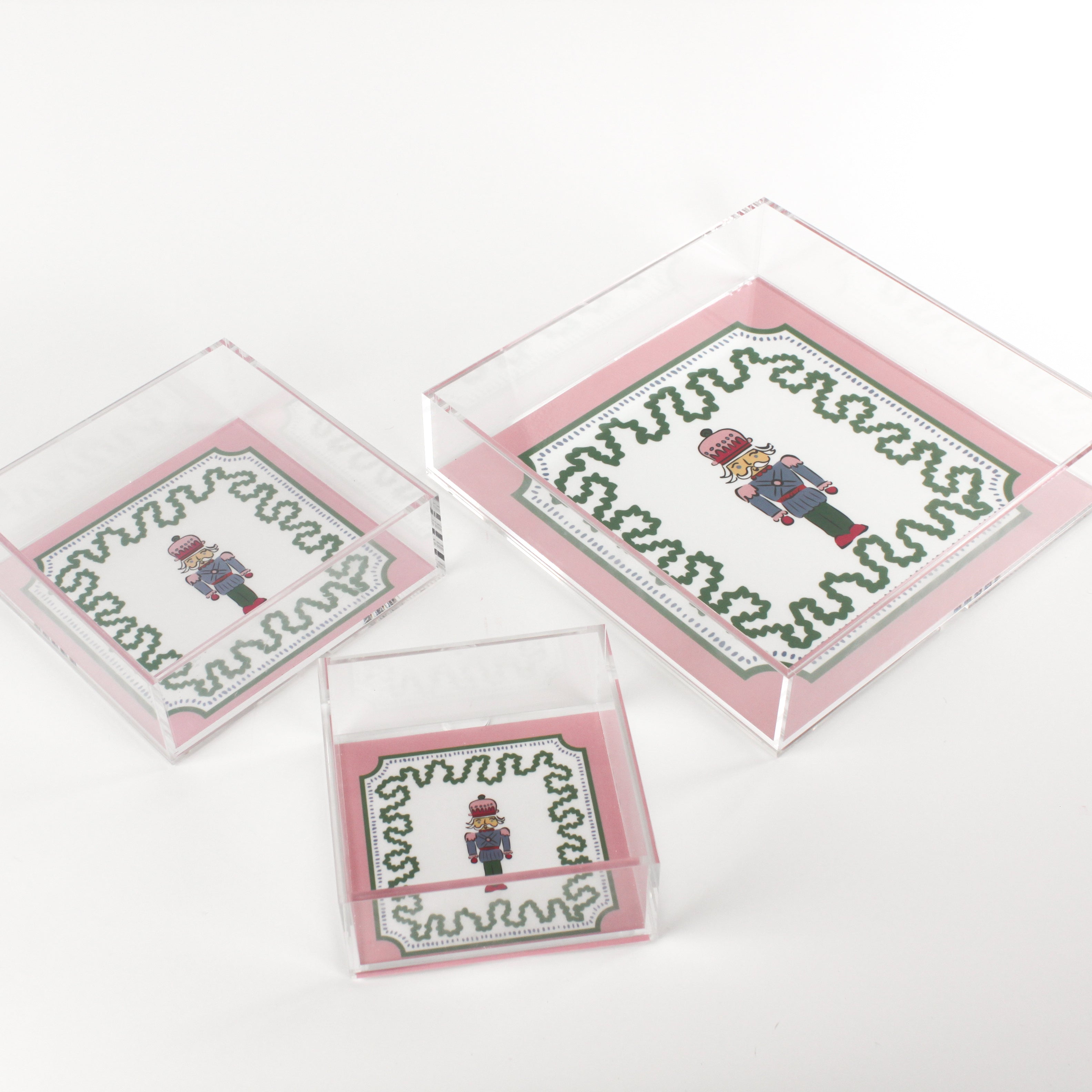 Nutcracker Square Acrylic Tray with in 3 sizes with pink and green border and Nutcracker in the center.