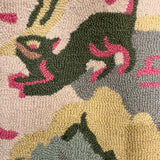 a close up of an Old Peking pink and green rug with chinoiserie motifs from madcap cottage focussing on a green animal