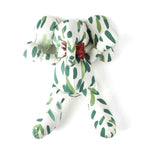 White stuffed elephant toy with green brushstroke pattern and red bow with white background.
