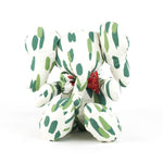 White stuffed elephant toy with green brushstroke pattern and red bow.