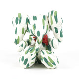 White stuffed elephant toy with green brushstroke pattern and red bow.