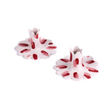 Pair of red and white ceramic petal-shaped candle holders with hand-painted red accents, designed for decorative tabletop display.