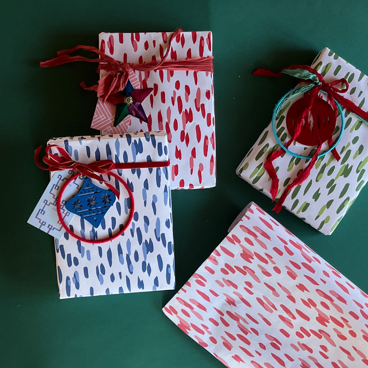 Four rolls of wrapping paper in painterly patterns and different colors.
