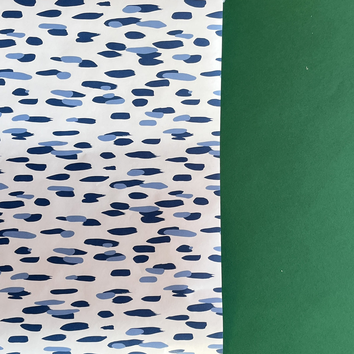A roll of wrapping paper in painterly patterns and blue in color.